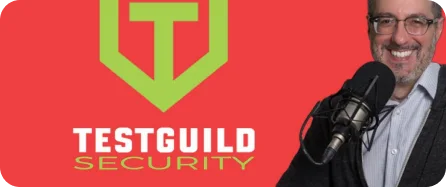 A man with a microphone in front of a red background with the words testguild security.