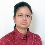 Person with tied-back hair wearing a red polka-dot shirt against a white background.