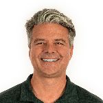 A man with gray hair smiles at the camera. He is wearing a dark green polo shirt. The background is plain white.